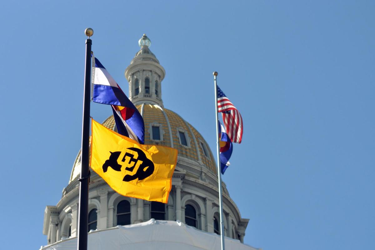 A CU, Colorado and United States flag at the Denver capitol building.