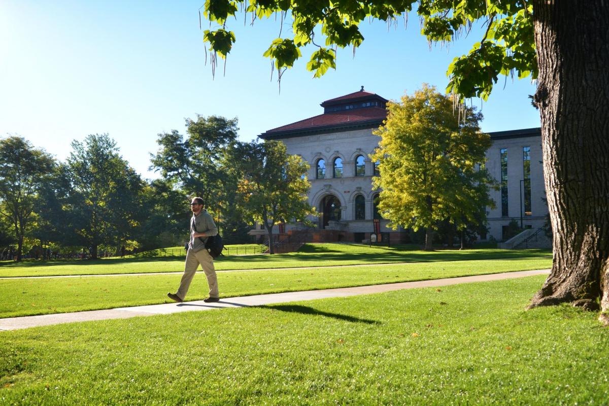 Campus community member walks across Norlin Quad