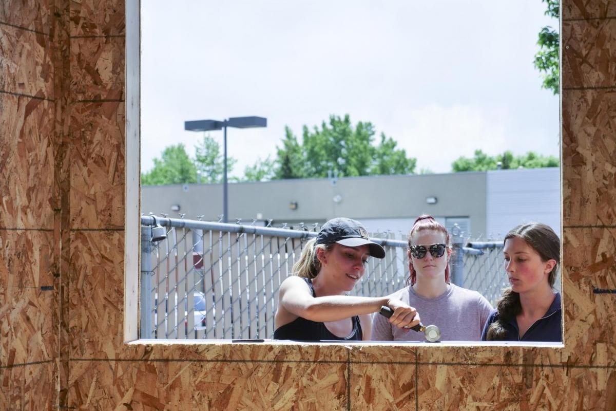 Students stand outside a pocket studio and talk.