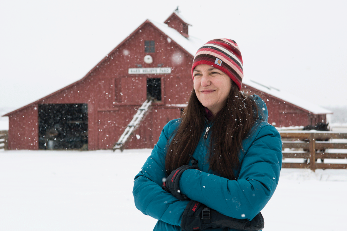 Rebecca Safran standing outside in the snow in front of a barn
