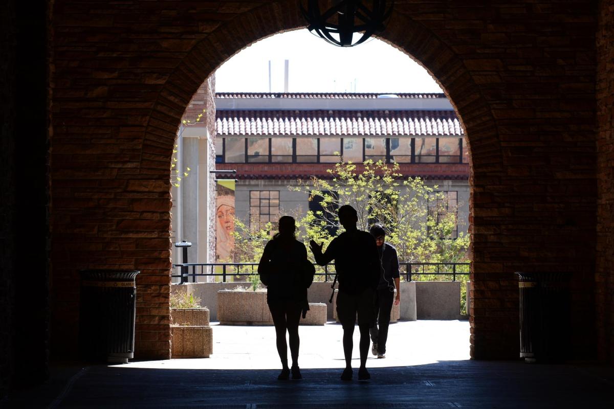 Students walking through UMC arch