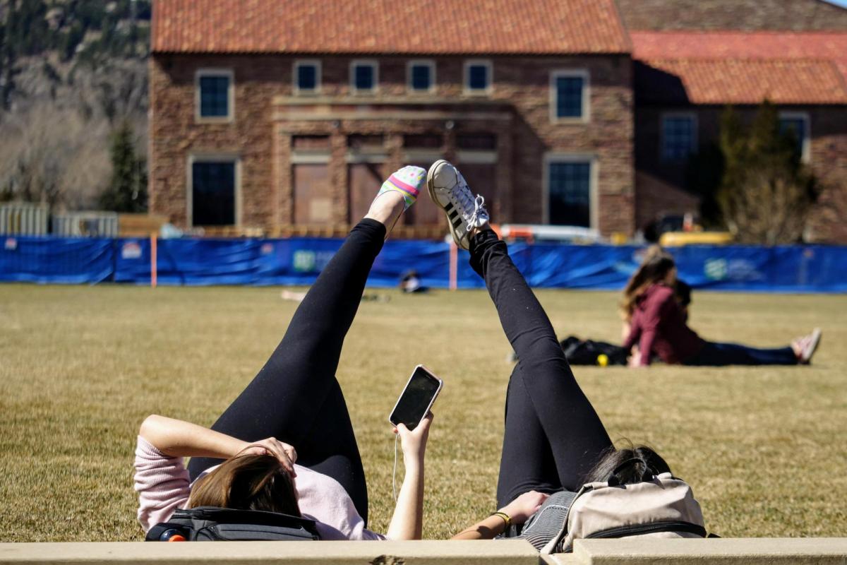 Two students lying in the grass of Farrand Field on the first day of spring