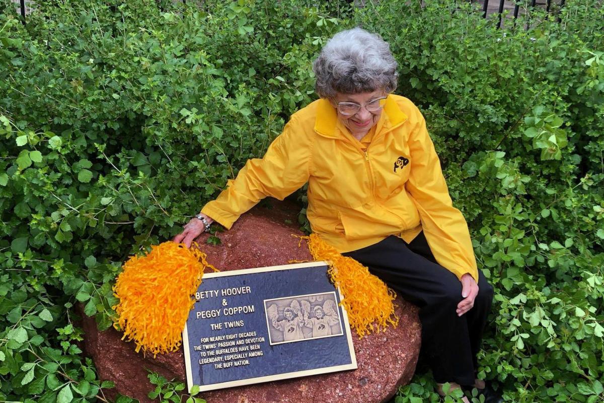 Peggy Coppom sits next to a plaque honoring her and her late twin sister, Betty Hoover. (Photo by Sarah Adderholt/University of Colorado)
