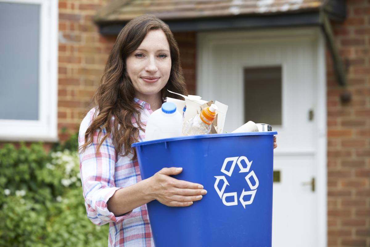 person holding a recycling bin full of items