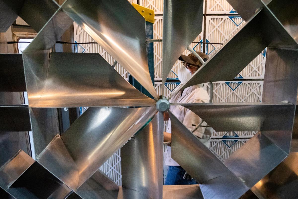 Maintenance worker viewed through a ventilation fan.
