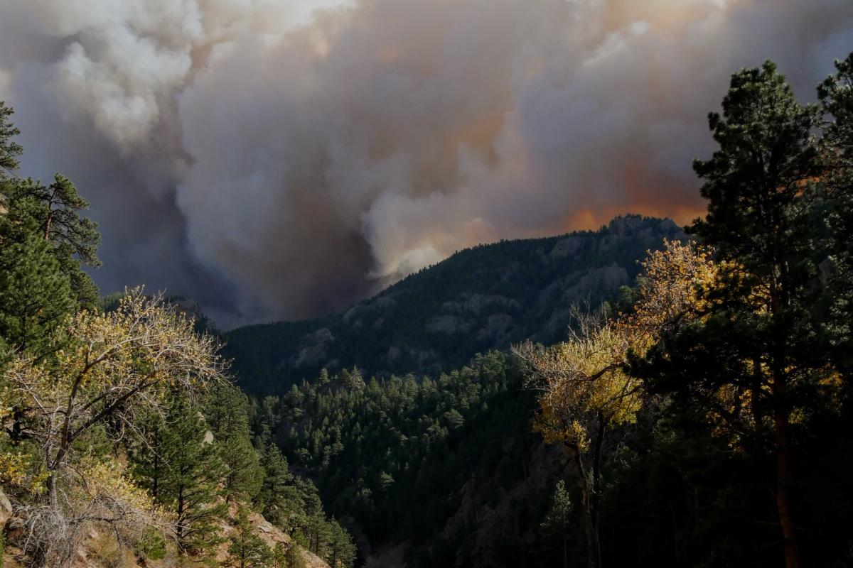 Orange light and smoke billow over mountain tops