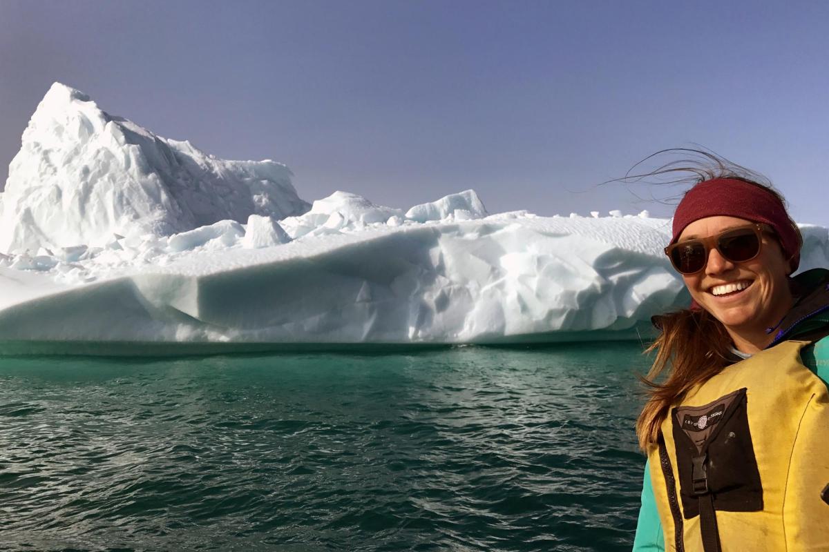 Graduate student Sarah Crump poses in front of an Arctic glacier