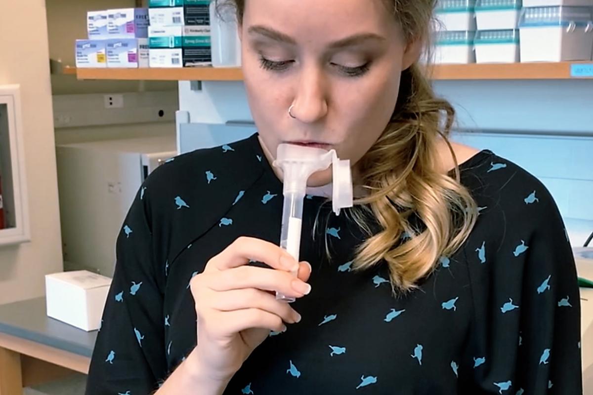 A researcher spits in a tube