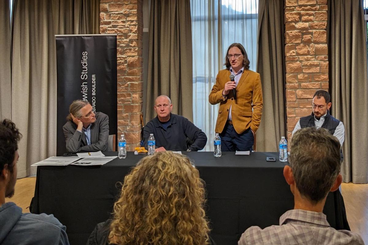Four faculty members at a table during a panel discussion.
