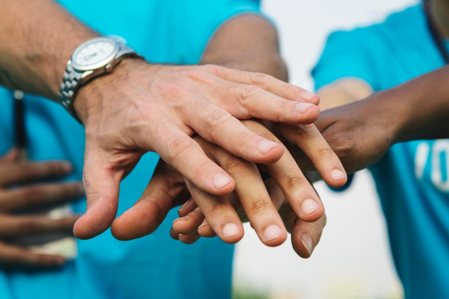 Circle of people put their hands together