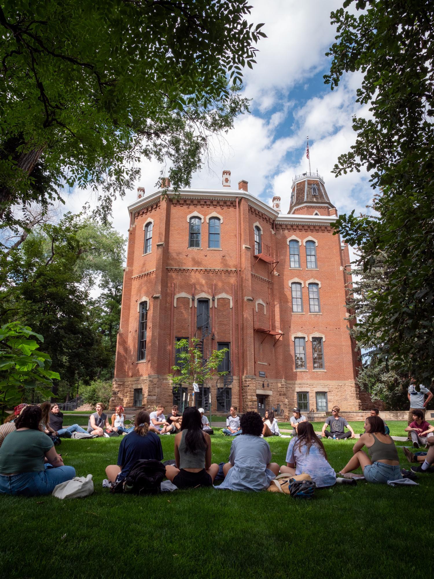 Class sits in a circle outside of Old Main