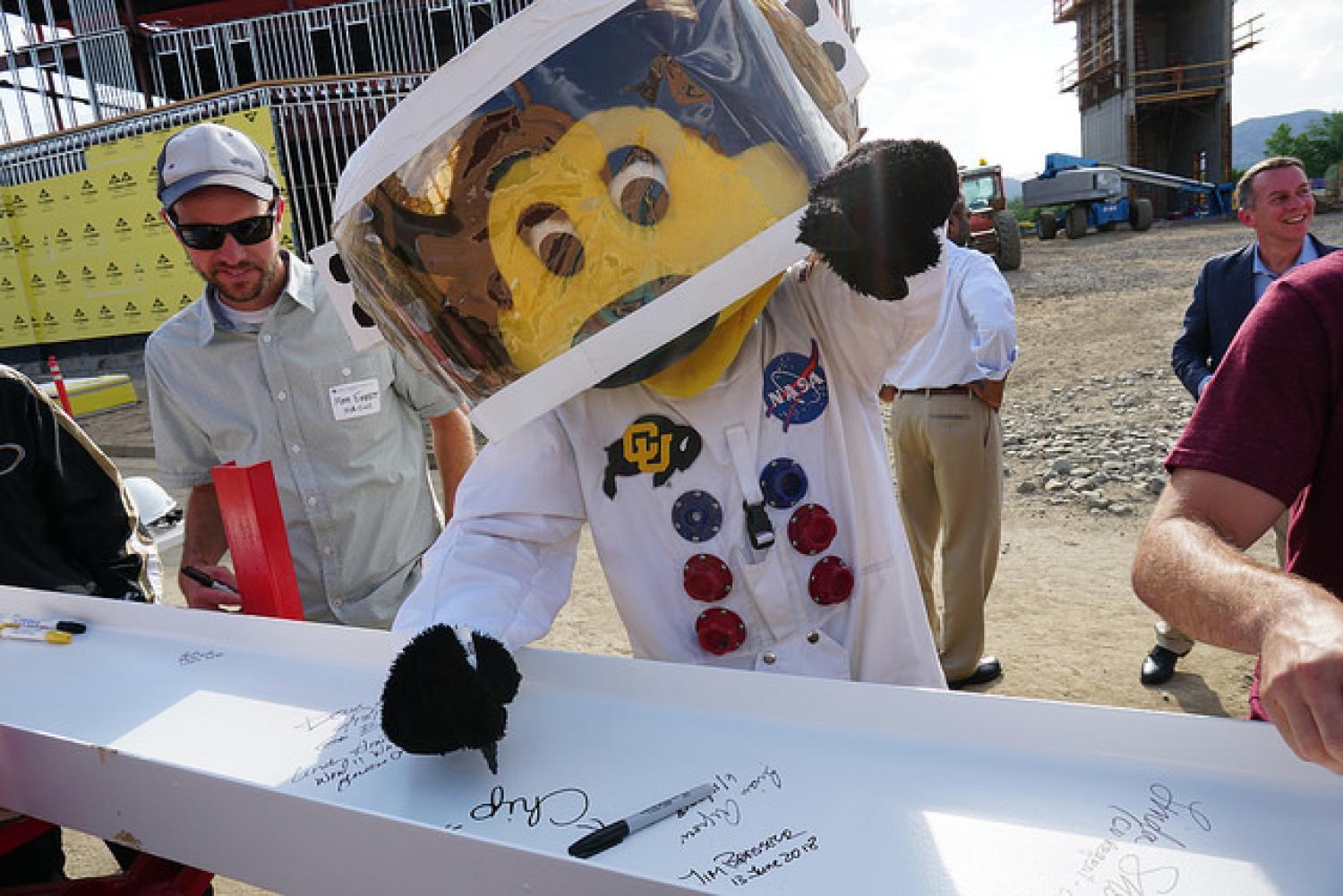 Chip signs a beam to be added to the new aerospace engineering building