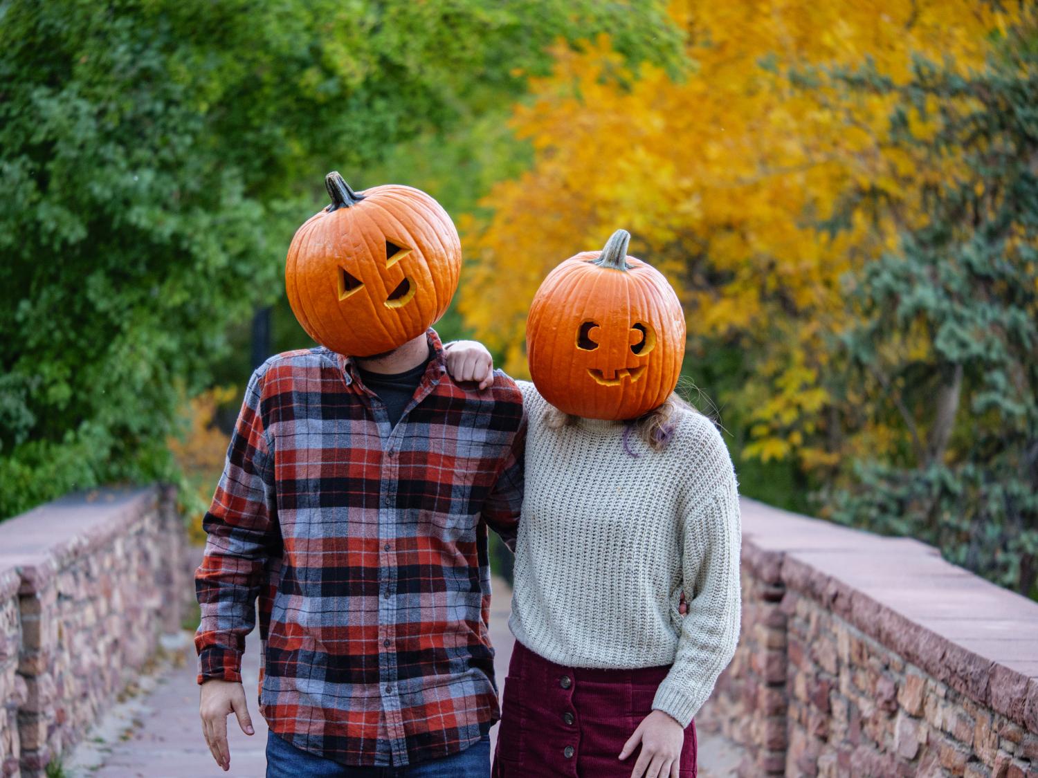 Two students wearing jack-o-lanterns on their heads