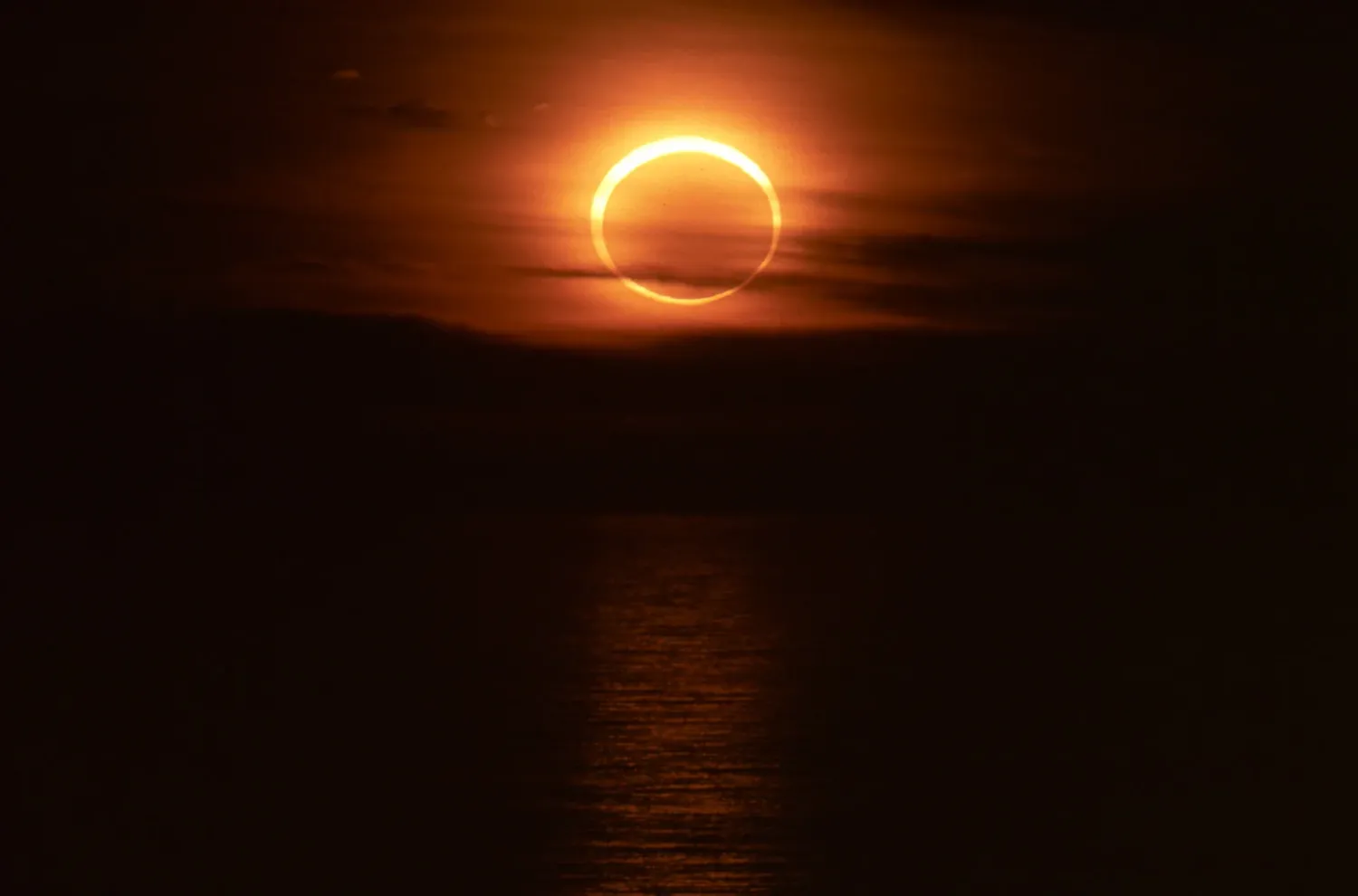Moon covers part of the sun over ocean