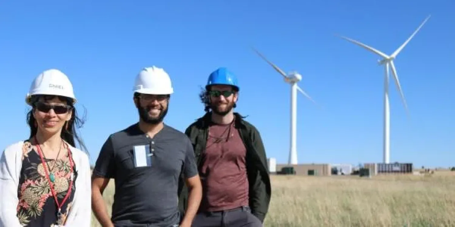 Scientists pose with windmills