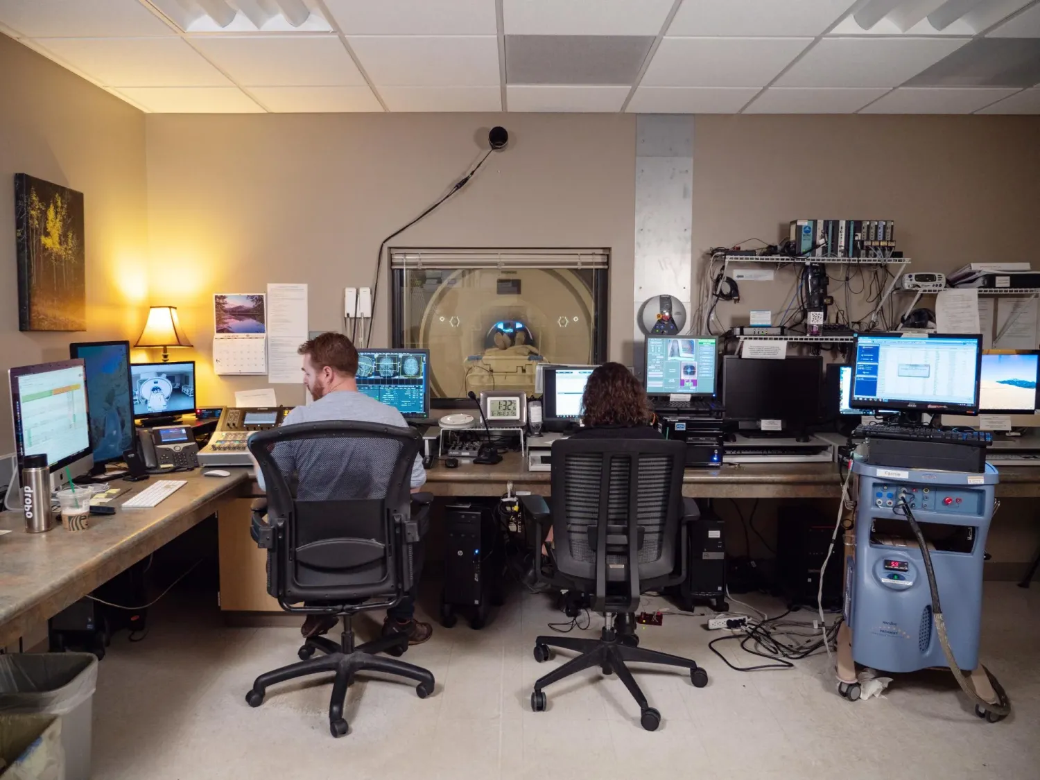 Two researchers operate an fMRI machine.