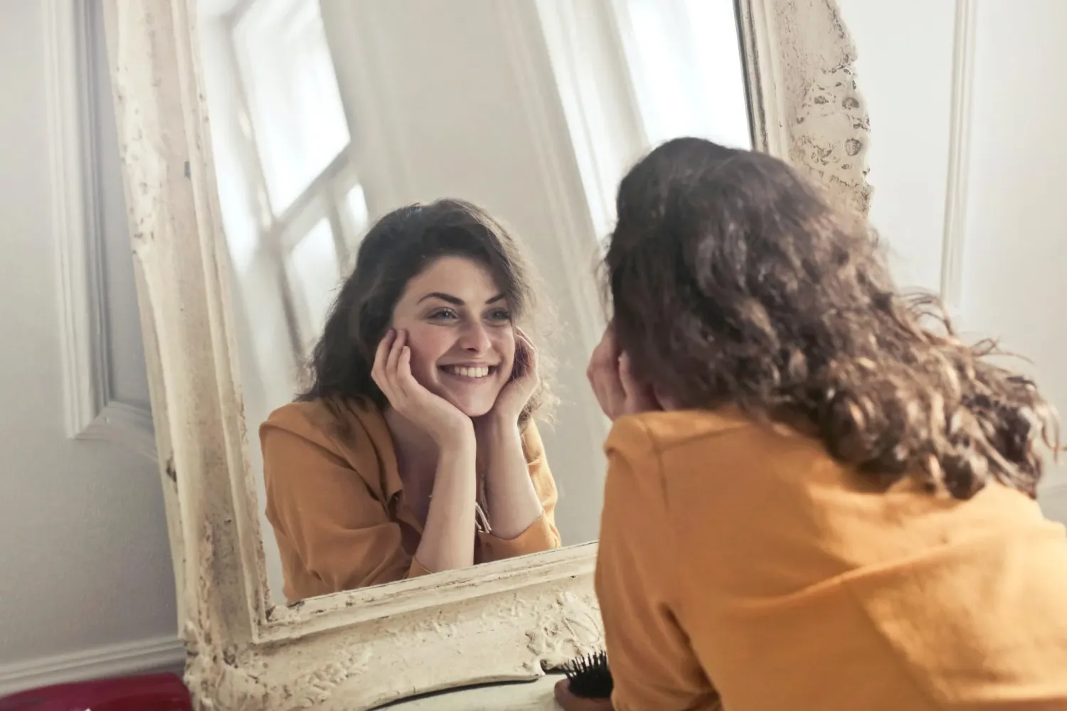 single person smiling at self in mirror