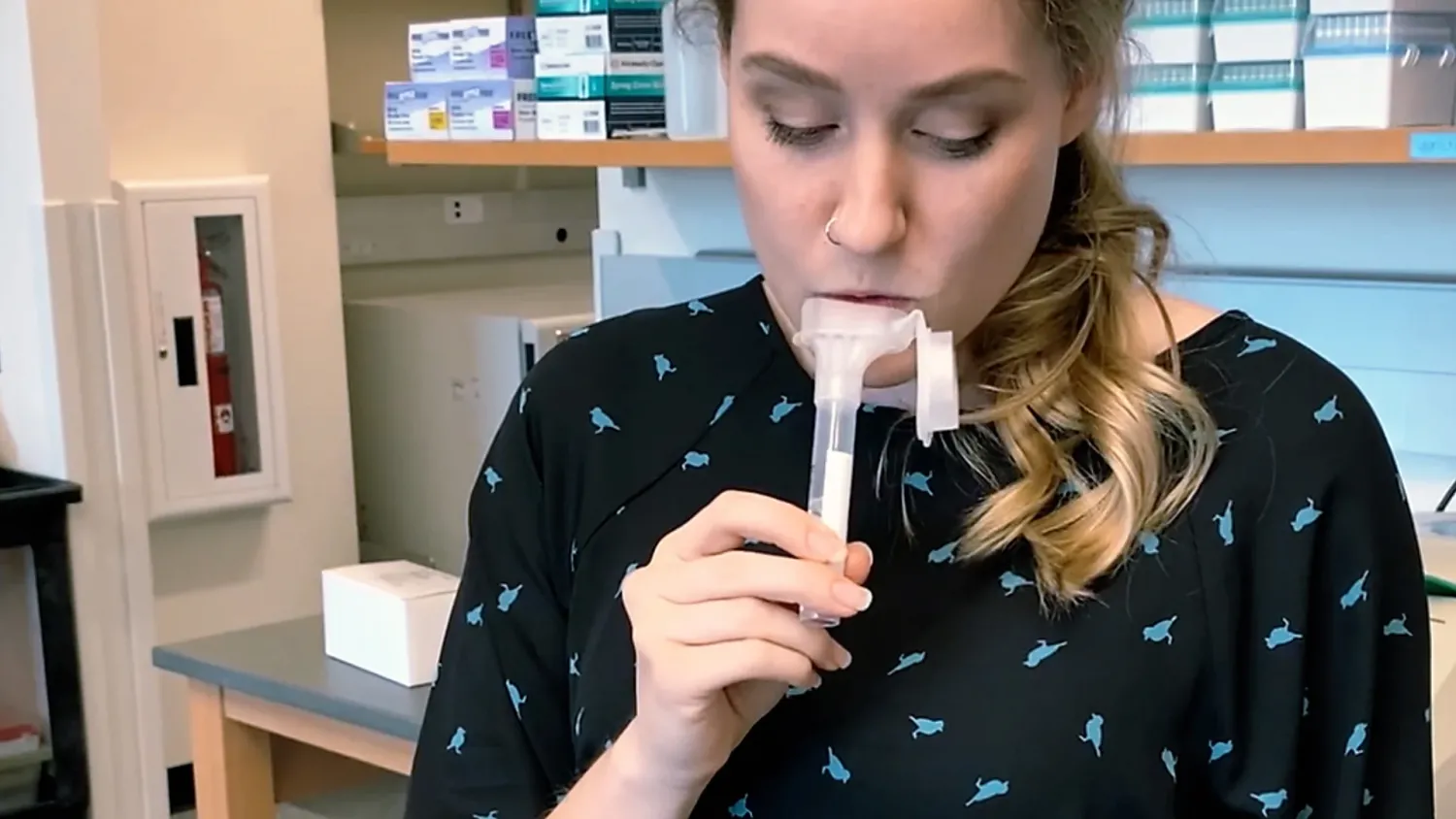 Researcher demonstrates a saliva-based COVID-19 test by spitting into a tube.