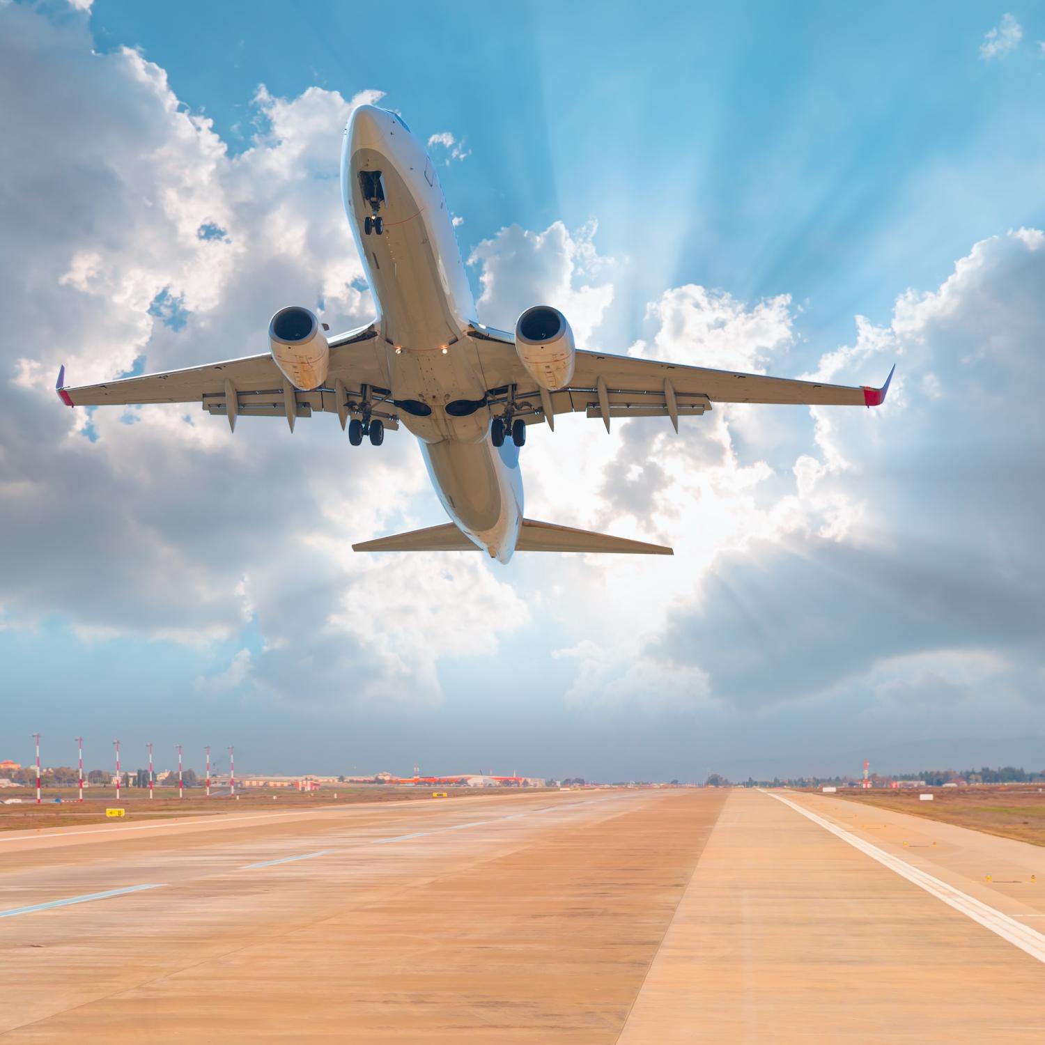 Airplane takes off from tarmac with clouds in the background