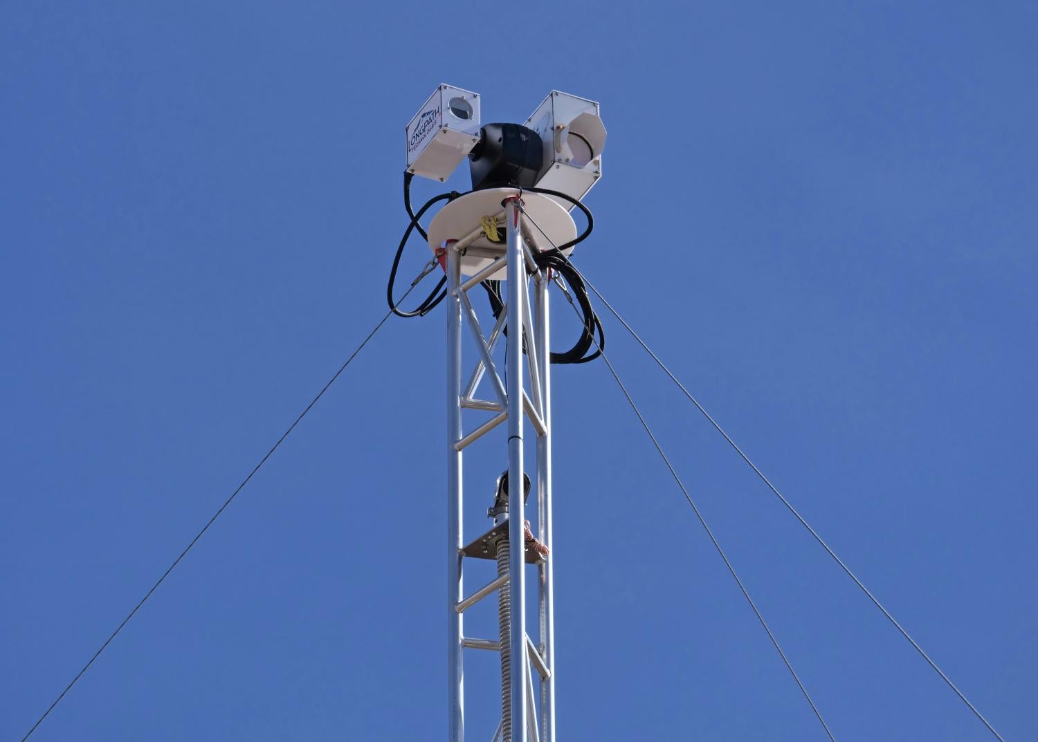 Equipment sitting on top of a metal scaffold with blue skies in the background