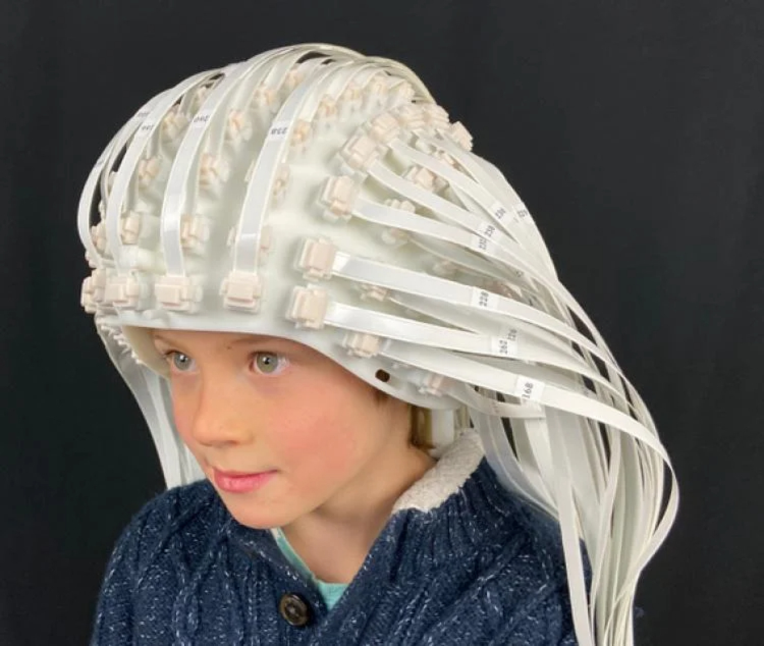 Child wearing helmet connected to a series of cables