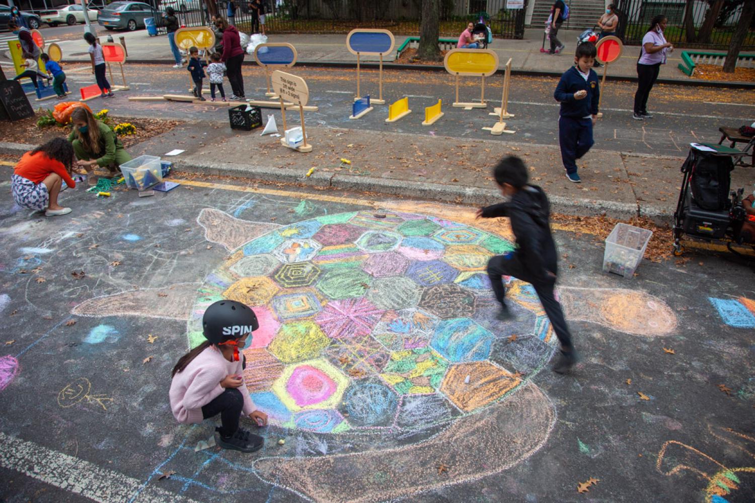 Children drawing and playing on the street in New York.