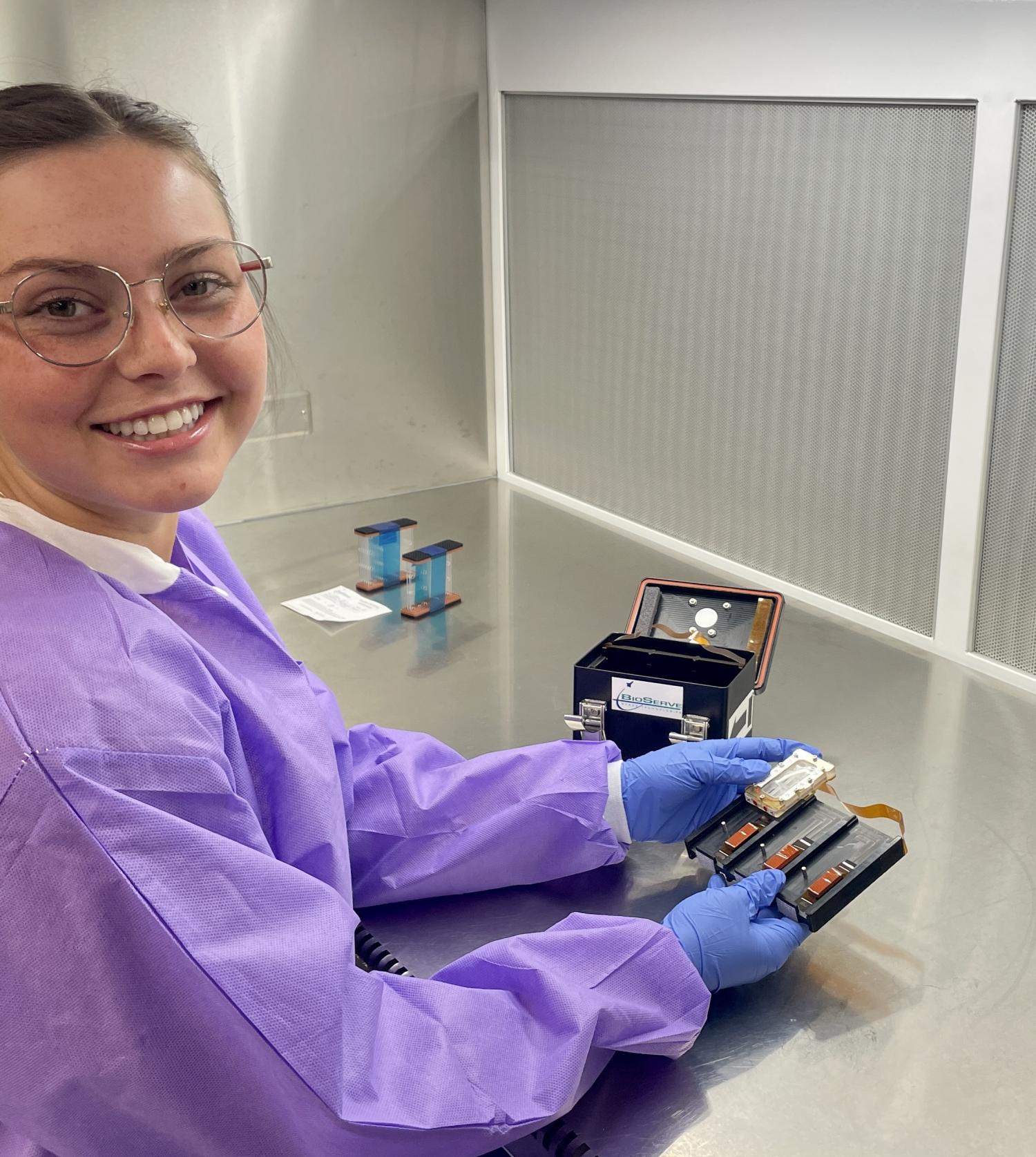 Woman wearing a safety jacket and gloves works in a scientific lab