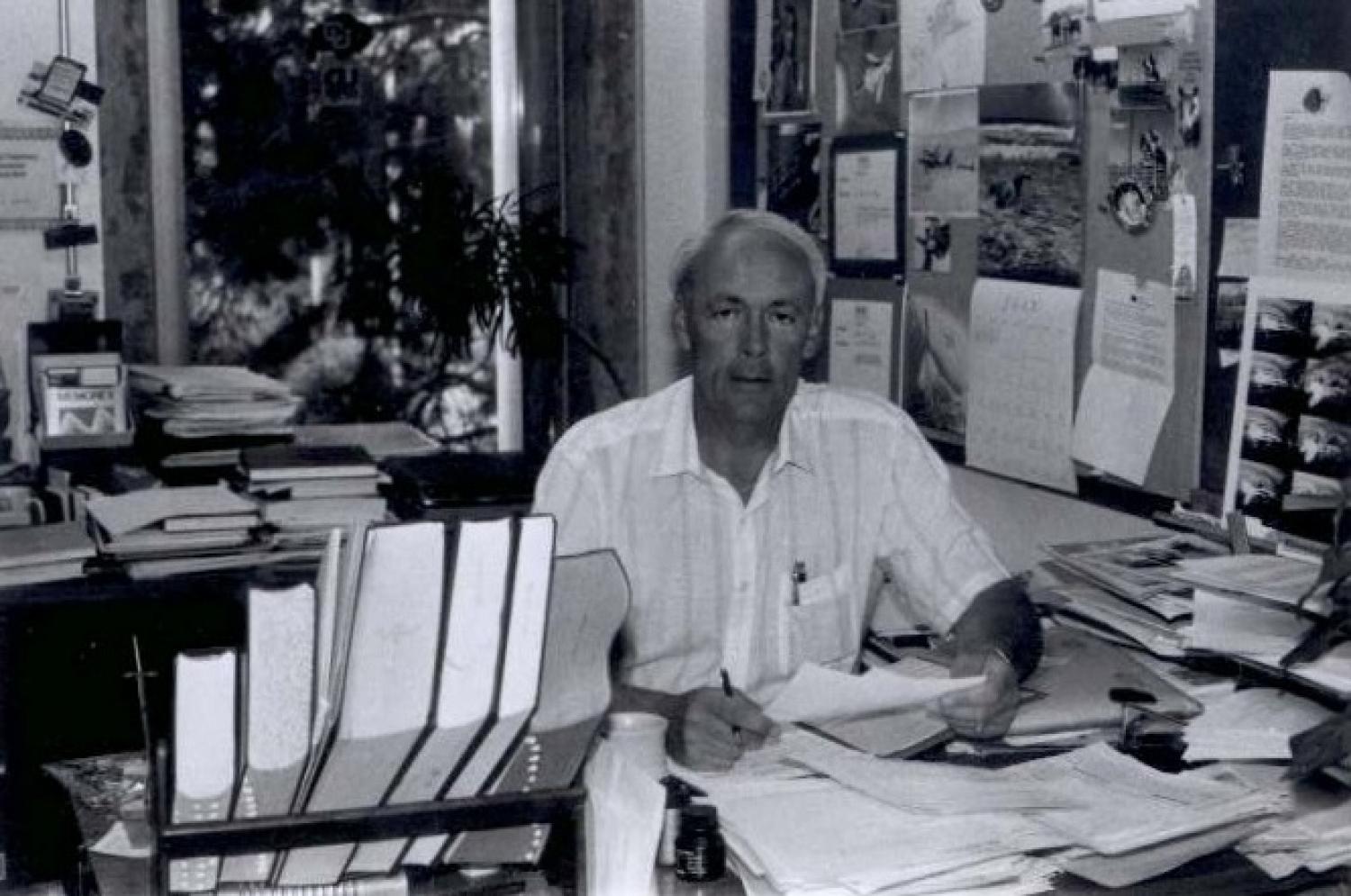 Man seated at desk in black and white photo