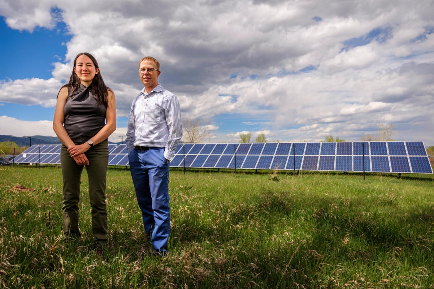 Kyri Baker and Bri-Mathias Hodge standing in front of a solar array.