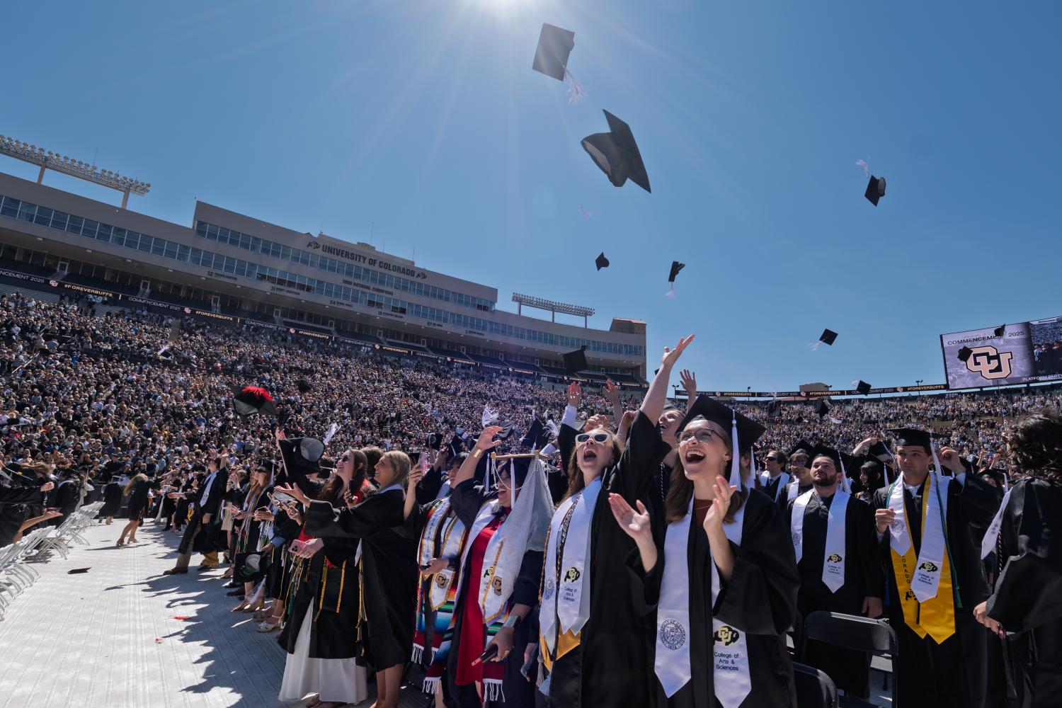Graduates throw their caps in the air