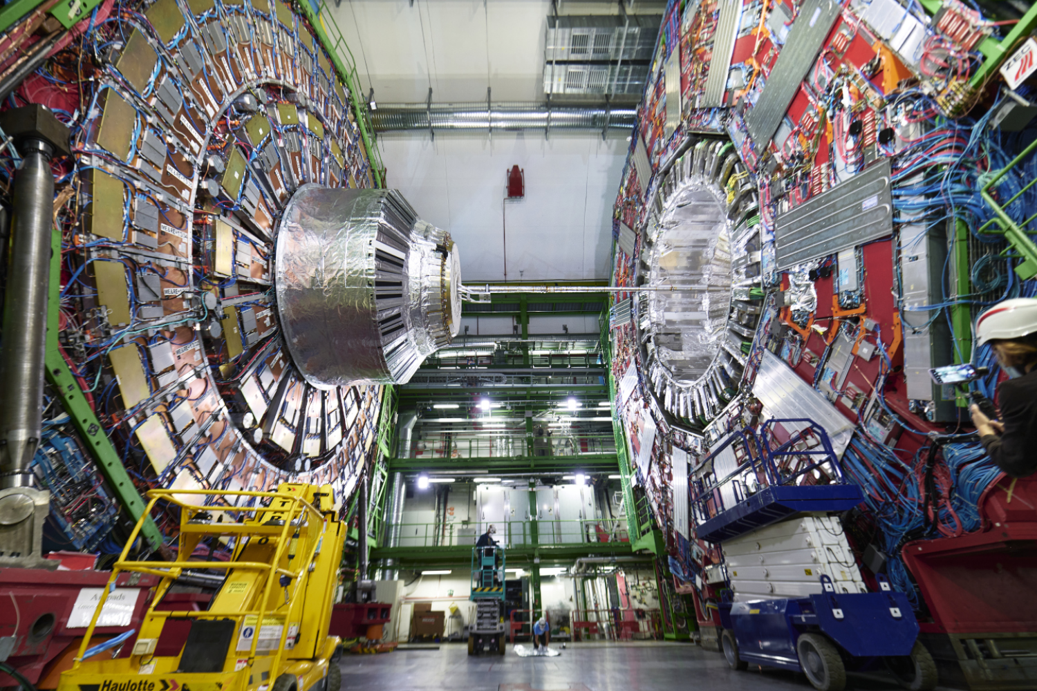 A cherry picker sits in front of a giant scientific device