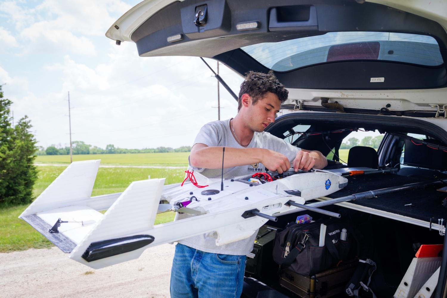 Man works on a small plane out of the back of an SUV