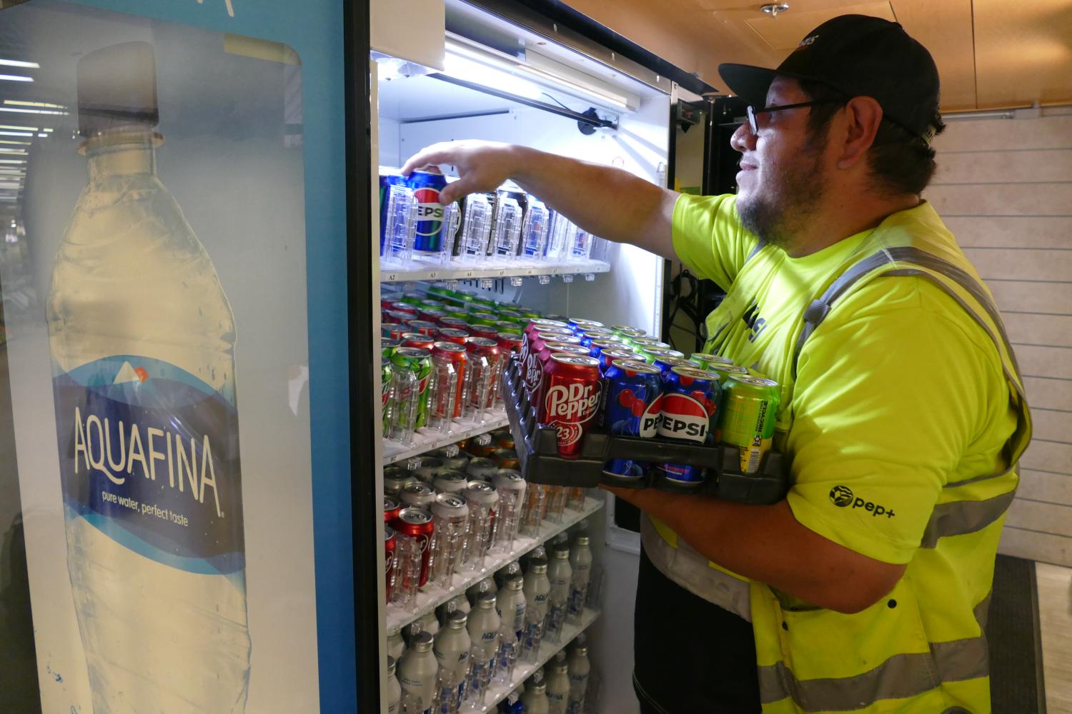 Pepsi employee loading drinks into a vending machine