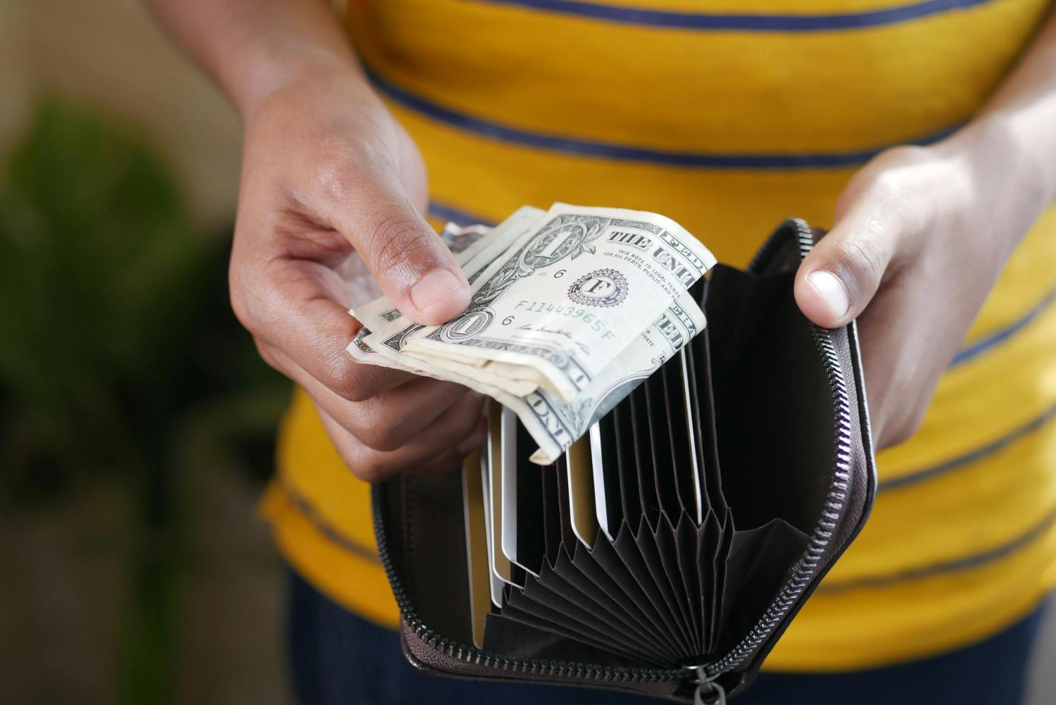 An open wallet with some dollar bills.