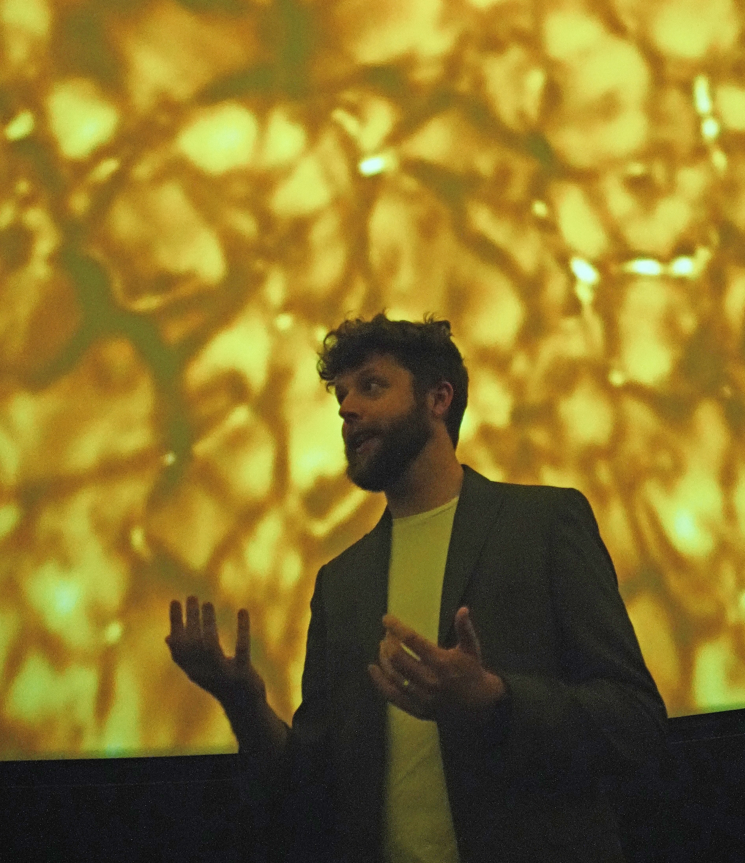 Man stands in front of image of something yellow and bubbling