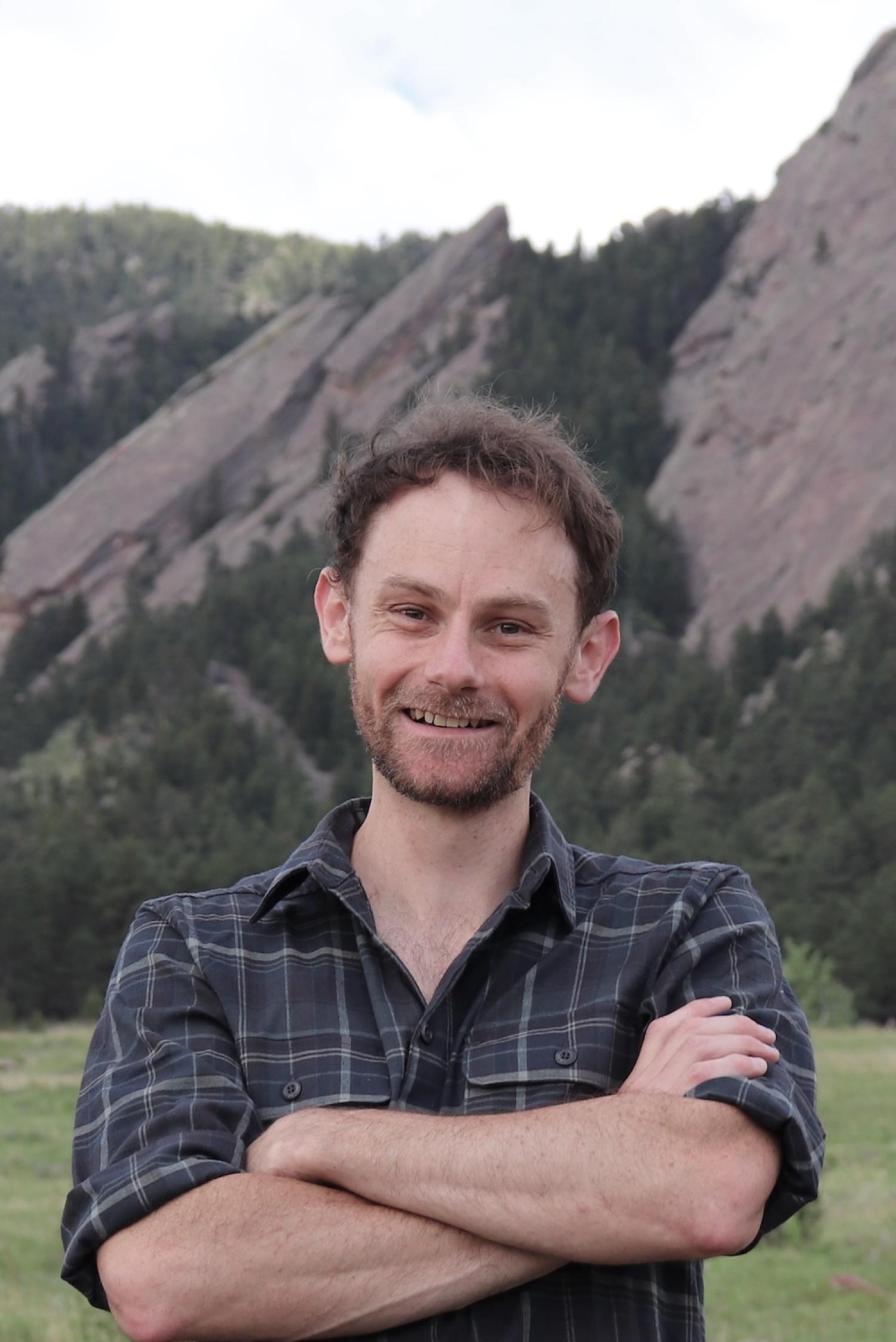 Man stands in front of rock formations