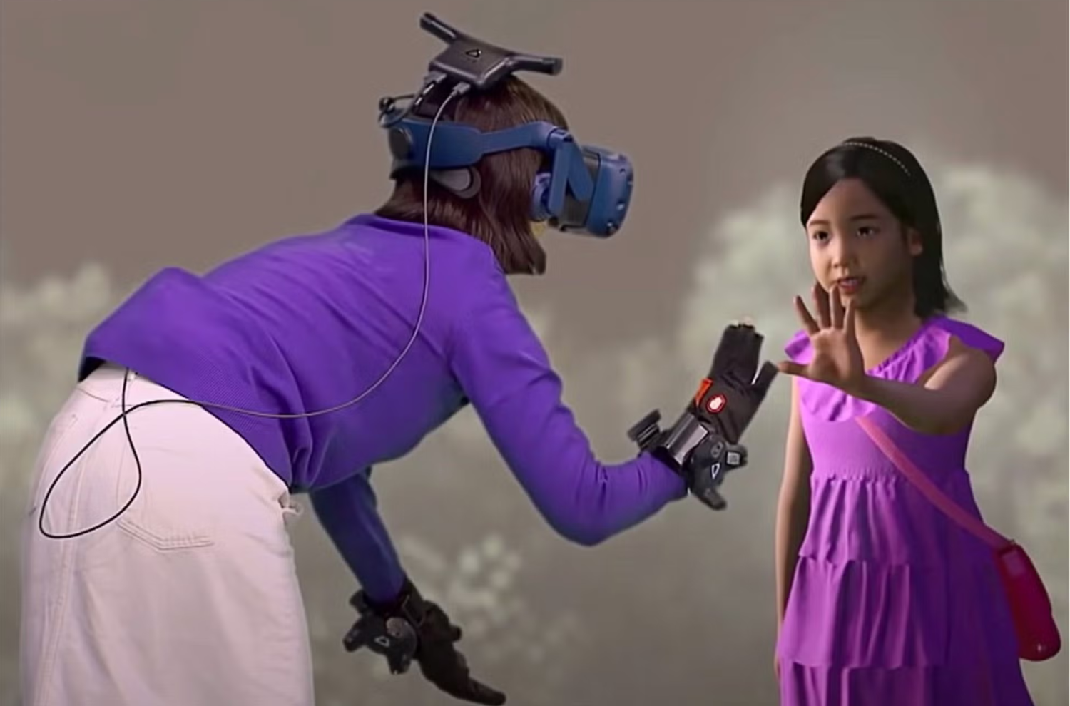 A woman wearing a VR headset touches her hand to the hand of a digital girl