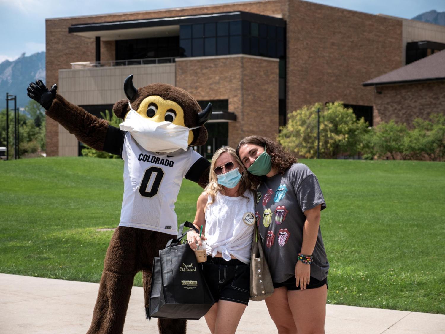 Student and parent pose for a photo with Chip the mascot during move-in