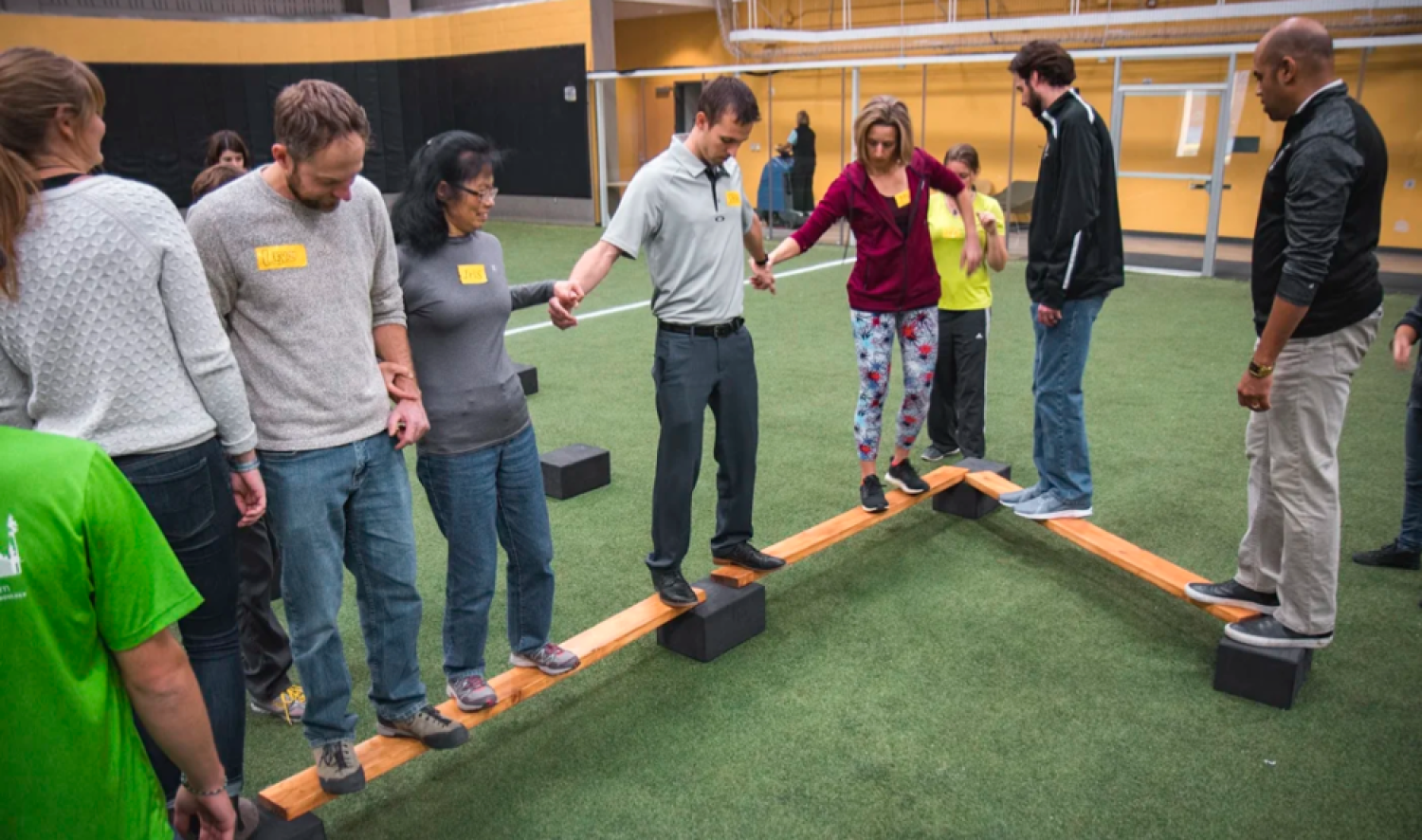 A group participates in an indoor challenge experience.