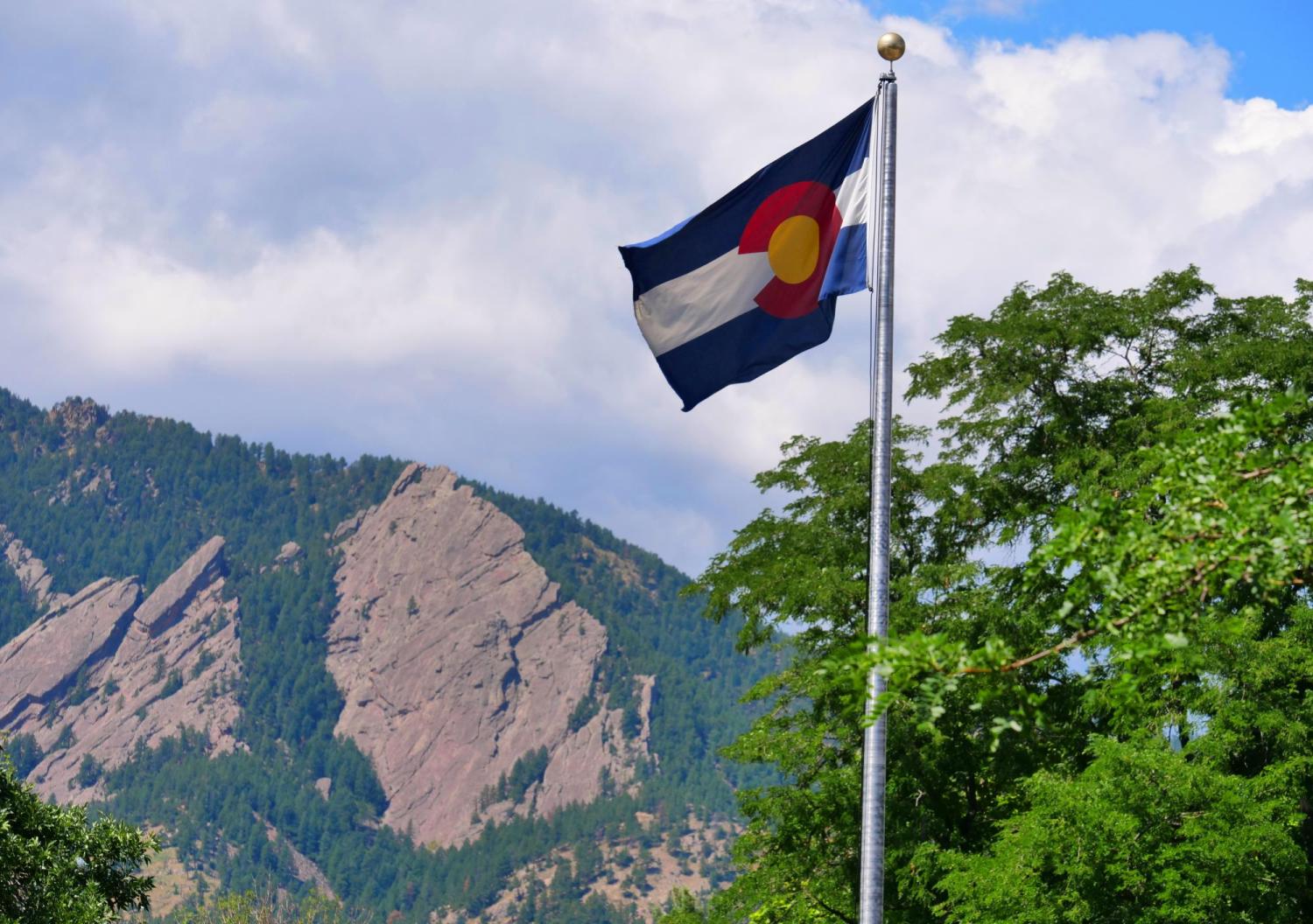 Colorado flag with Flatirons in the background