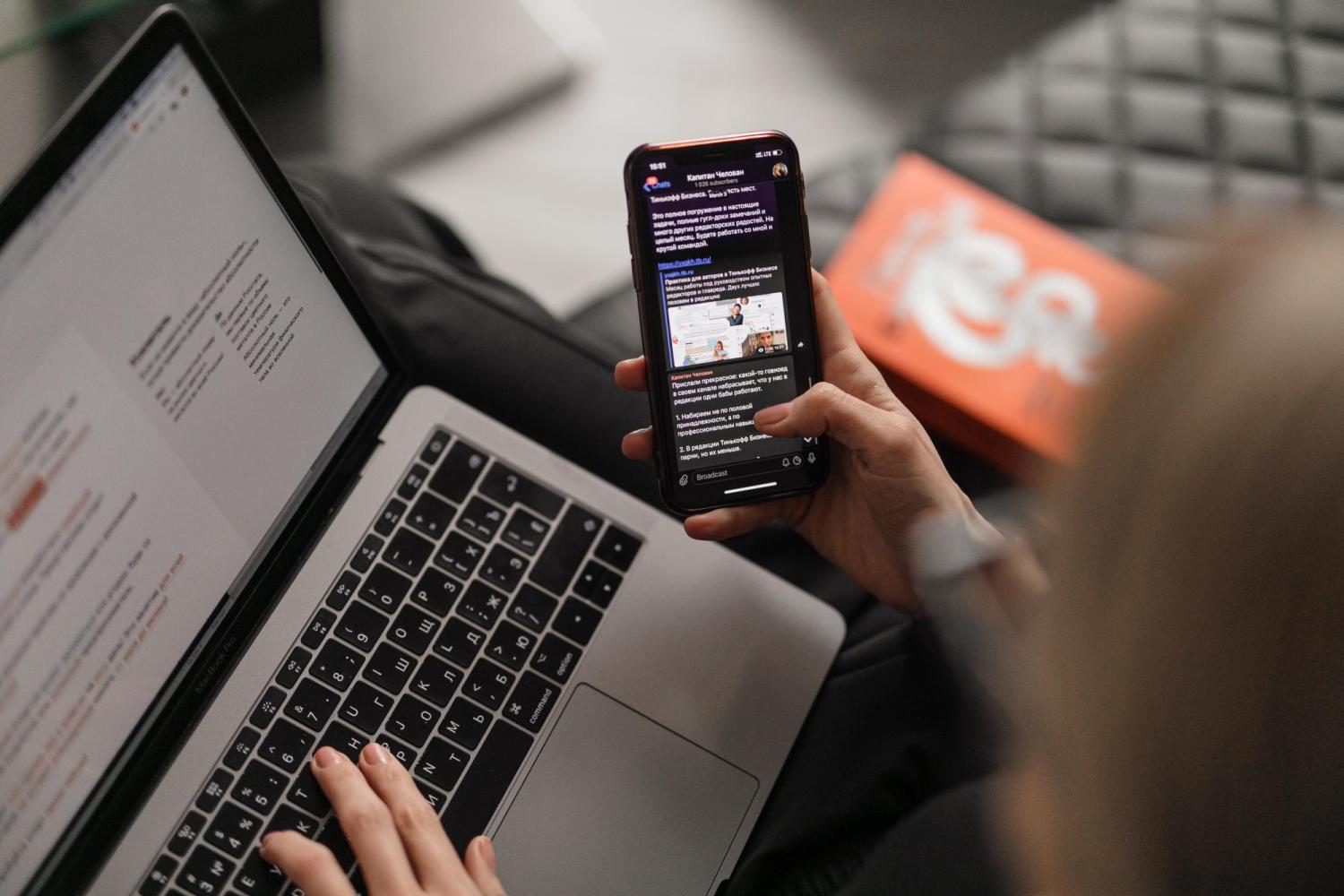 person checks phone and laptop