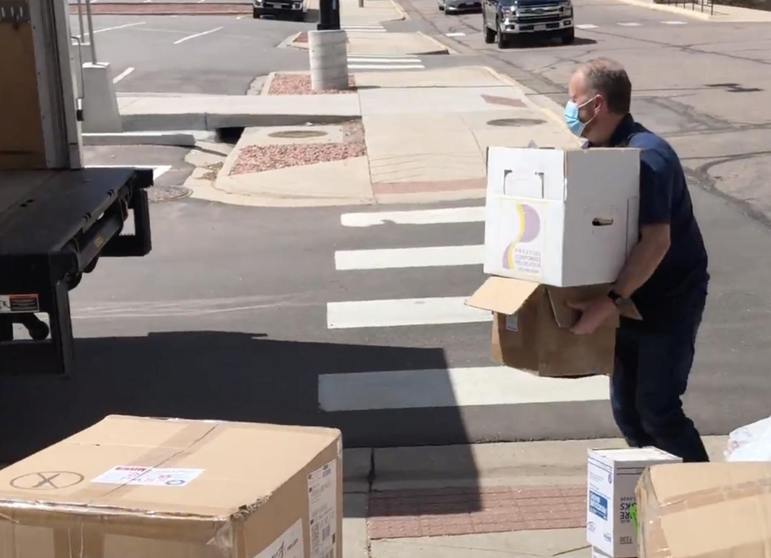 A person loading PPE supplies into a truck