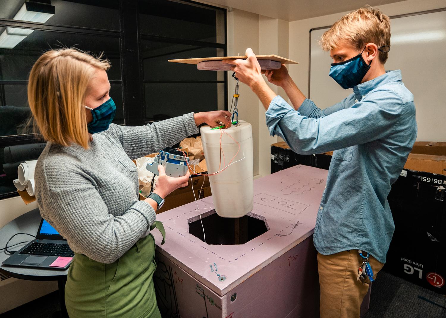Evan Kirk and Claire Meyer demonstrate how thermal testing for the PortaVax device is set up. (Photo submitted)