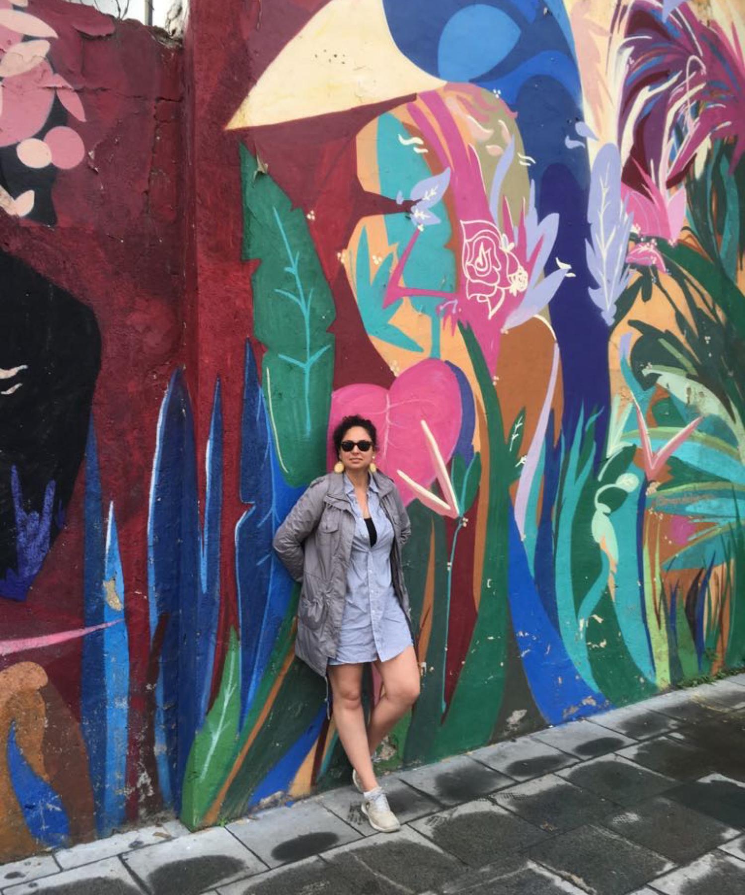 Jo Marras Tate in front of a mural