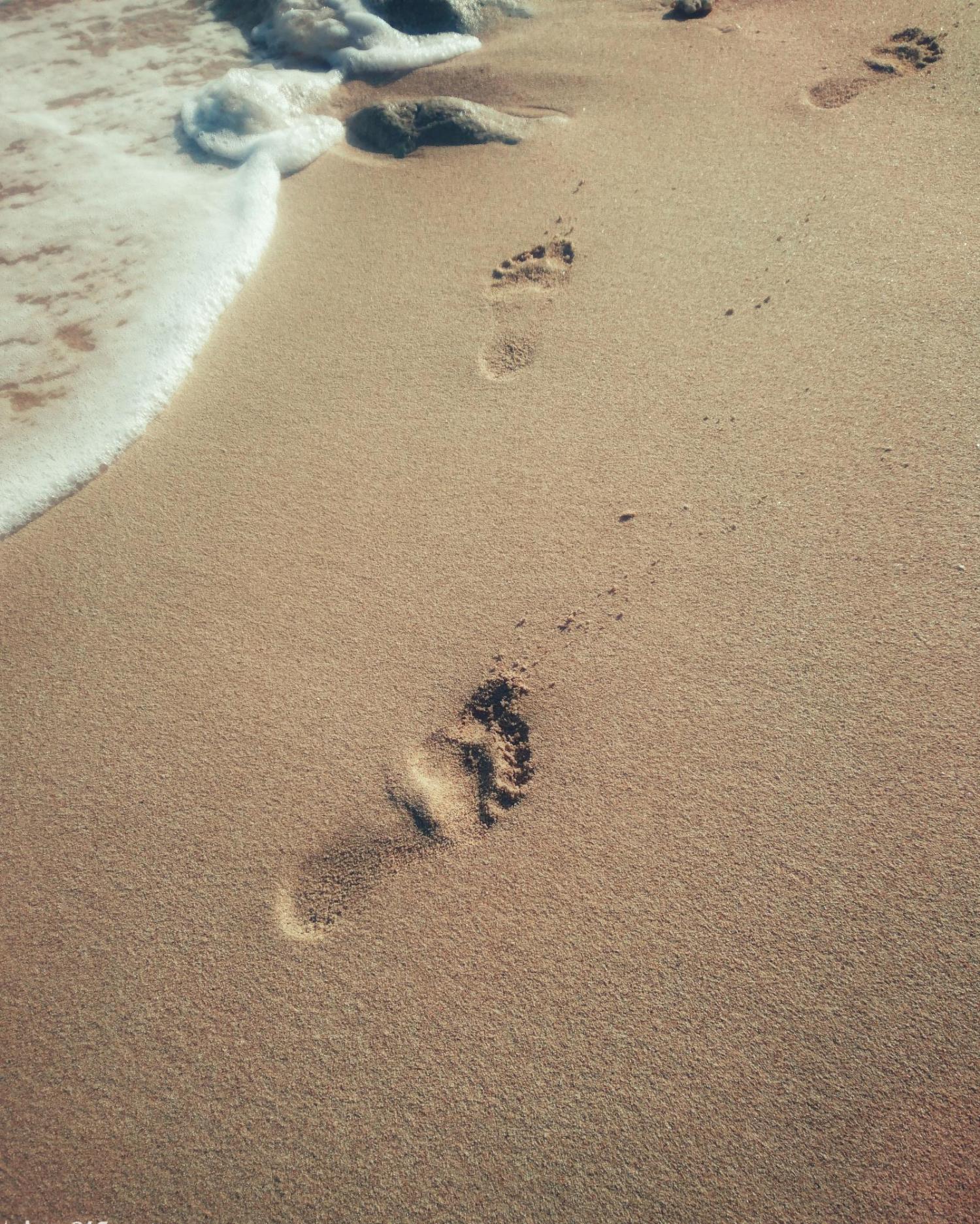 footprints near ocean shore