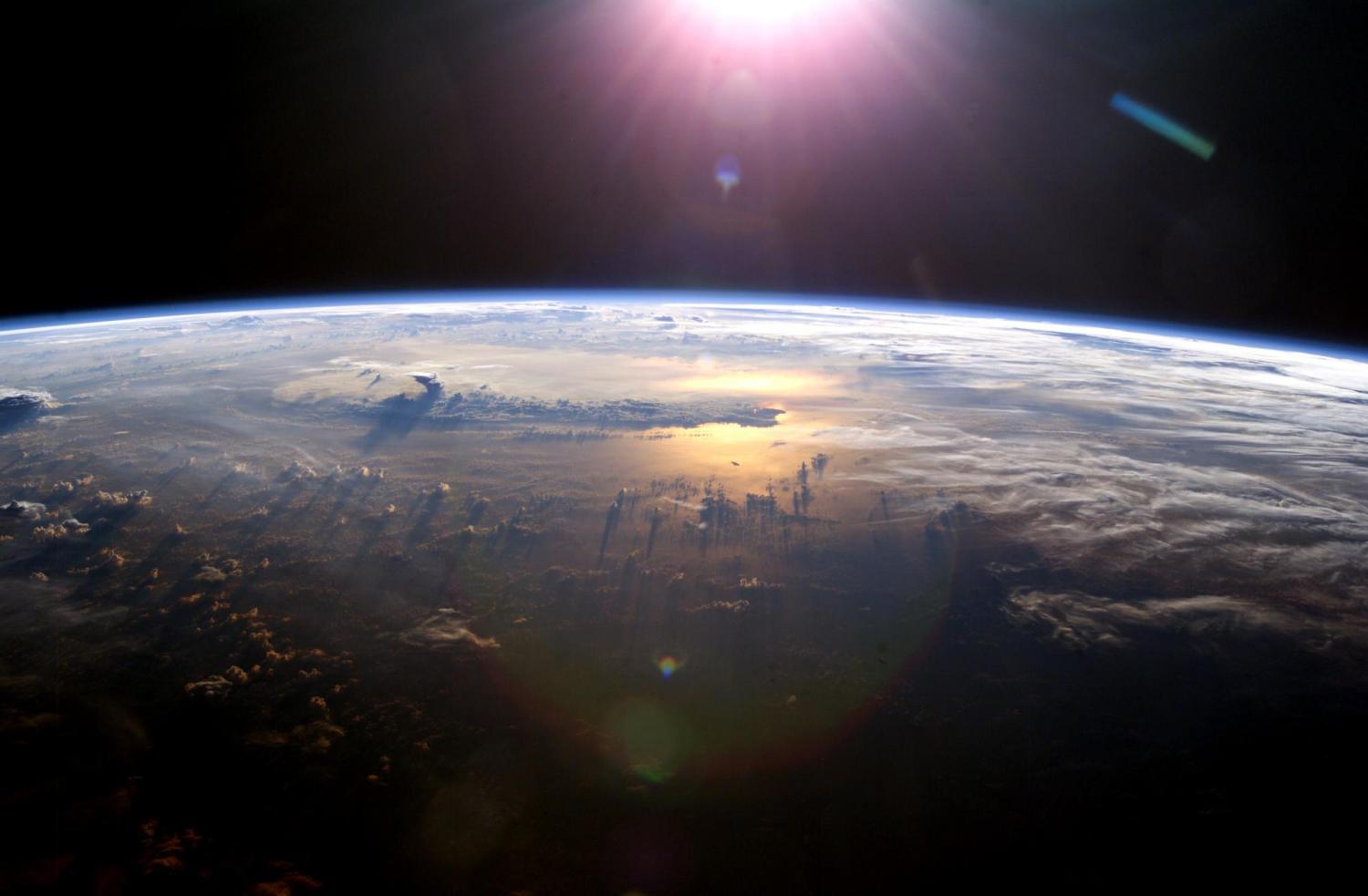 Sun rises above the Earth as seen from space.