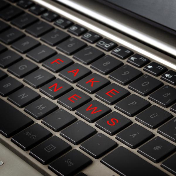 a keyboard displaying the words "fake news"