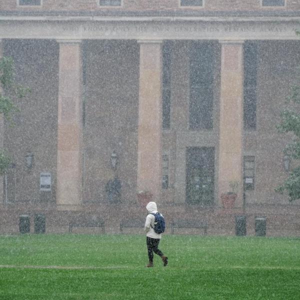 Students walk past Norlin Library during the first snow of the fall 2020 semester on the CU Boulder campus. (Photo by Glenn Asakawa/University of Colorado)