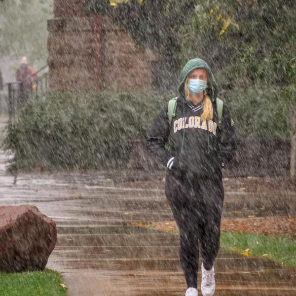 Students walk through the first snow of the fall 2020 semester on the CU Boulder campus. (Photo by Glenn Asakawa/University of Colorado)