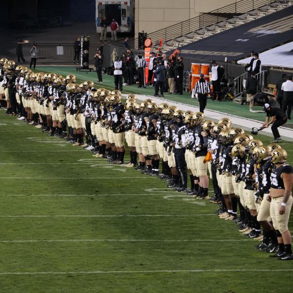 CU players and staff link arms in solidarity before their game against UCLA on Saturday, Nov. 7, 2020. (Photo by Glenn Asakawa/University of Colorado)